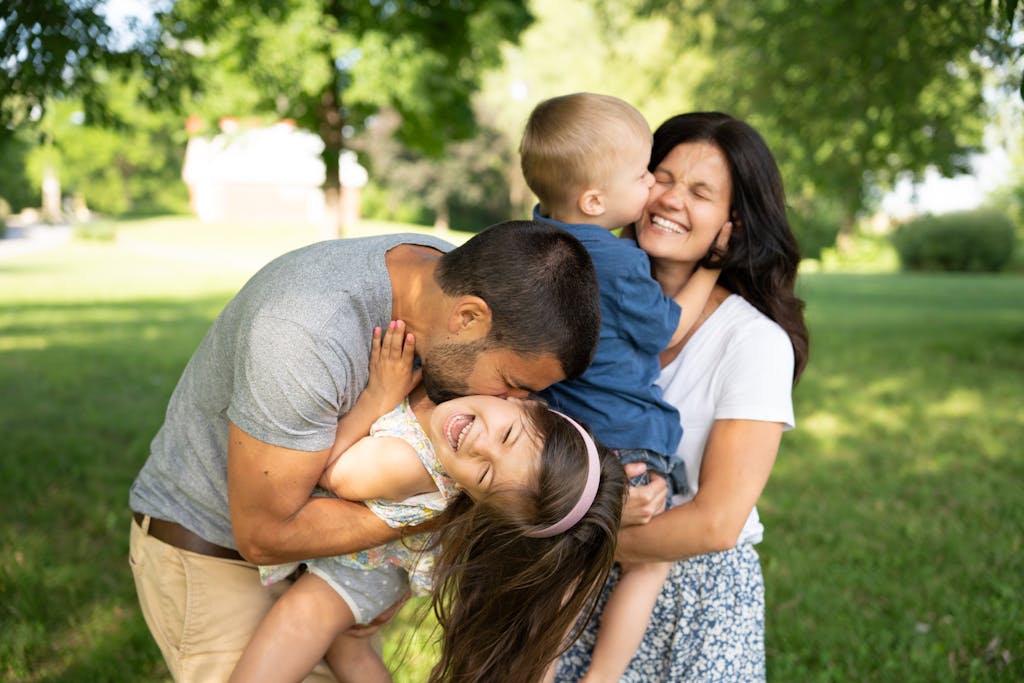 A family is hugging each other in the grass